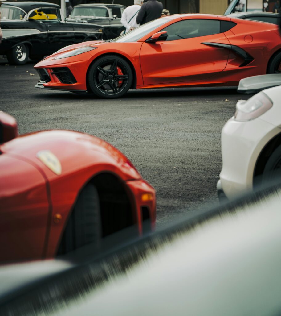 Red sports car showcased at an outdoor auto event, highlighting luxury and design.