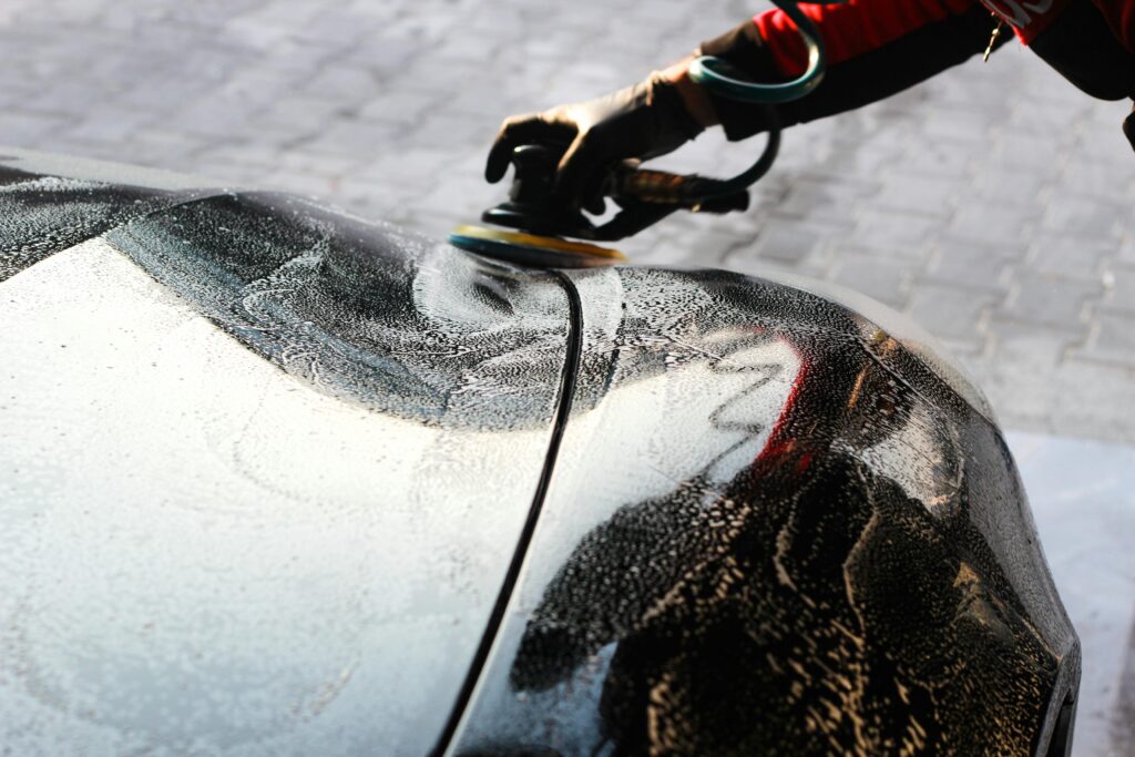 Close-up of a car being polished by hand, showcasing professional detailing and maintenance.